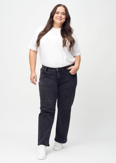 Fuldt billede af en plus-size model i mørkegrå denim loose jeans.