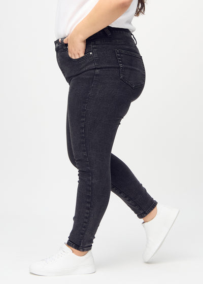 Mørkegrå denim skinny jeans set fra siden på en plus-size model.