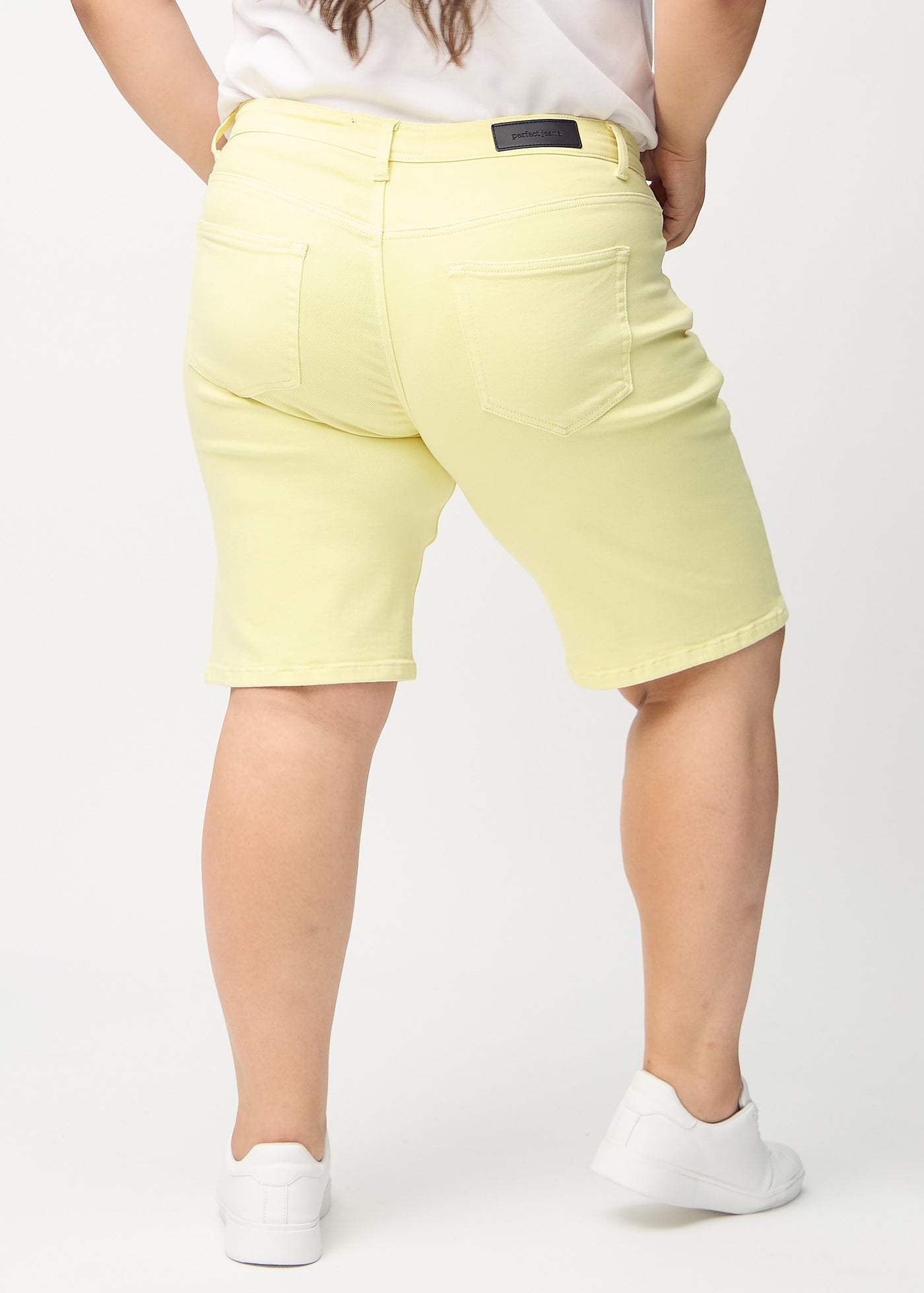 Lysegule regular middle shorts set bagfra på en plus-size model, så man kan se hele produktet.