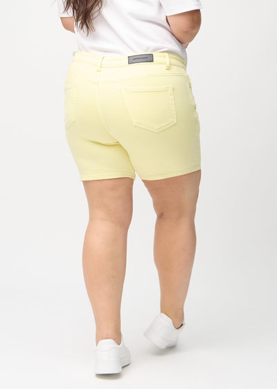 Lysegule skinny short shorts set bagfra på en plus-size model, så man kan se hele produktet.