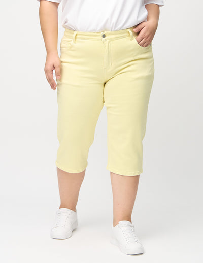 Lysegule regular capris, modelnavn Lemonades, som går lige ned langs benet på en plus-size model, set forfra.
